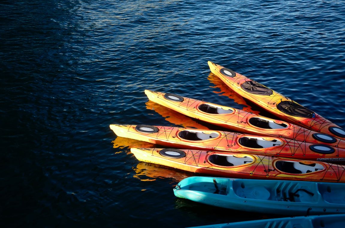 several colorful kayaks on lake
