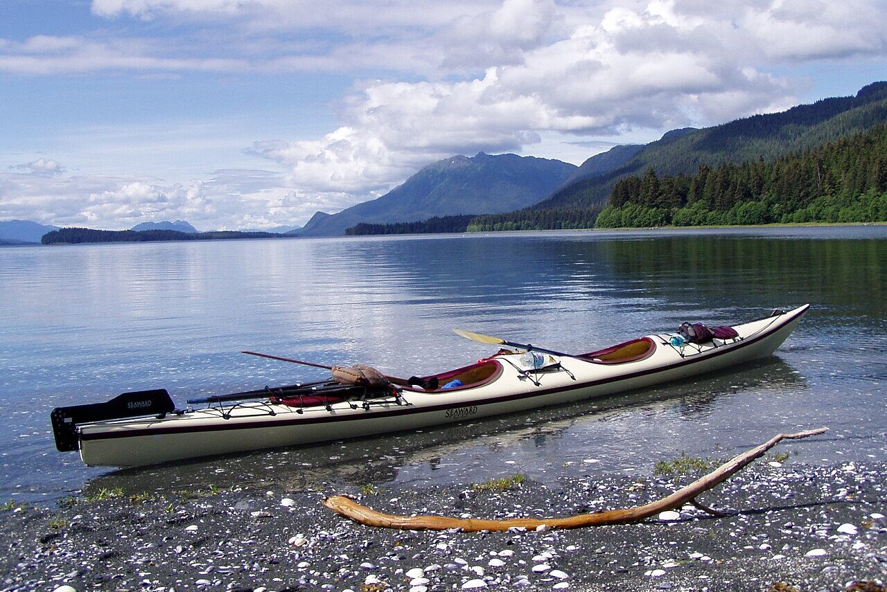 tandem kayak drifting in Seymour Canal, Alaska, surrounded by natural beauty