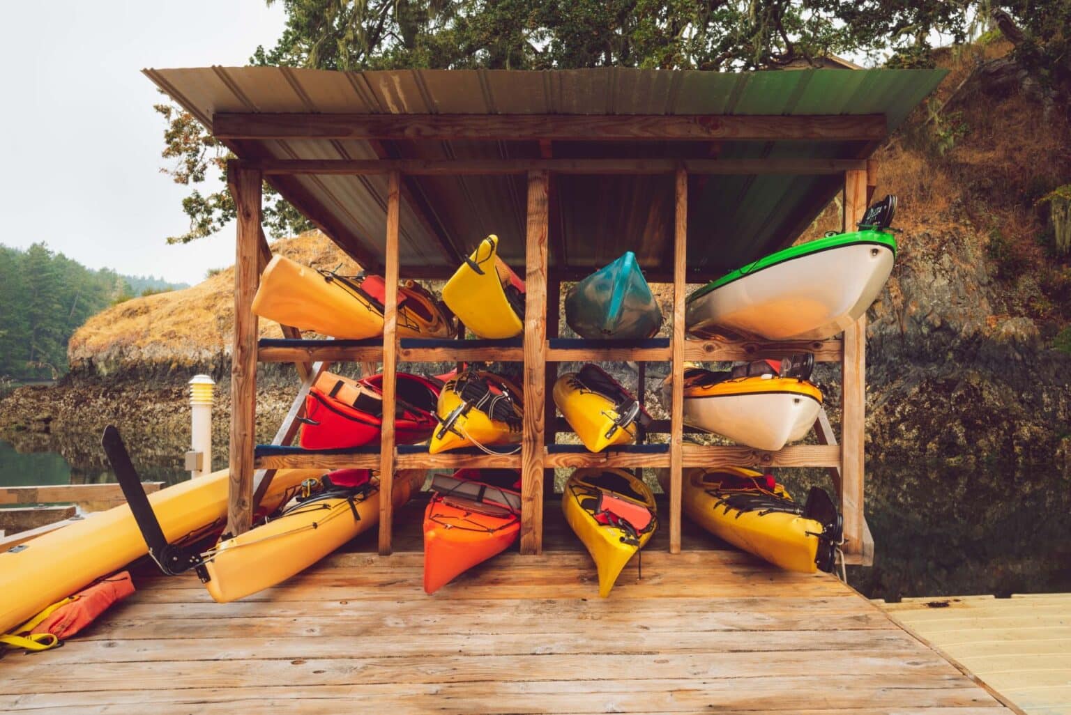 Collection of kayaks organized in a wooden kayak storage unit