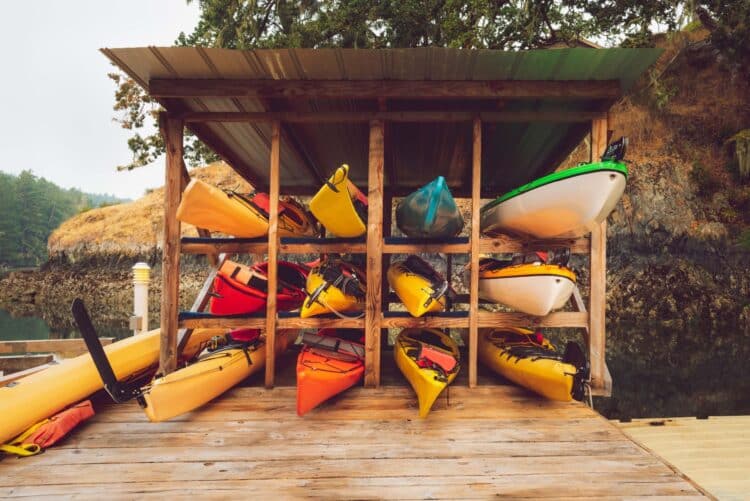 Collection of kayaks organized in a wooden kayak storage unit