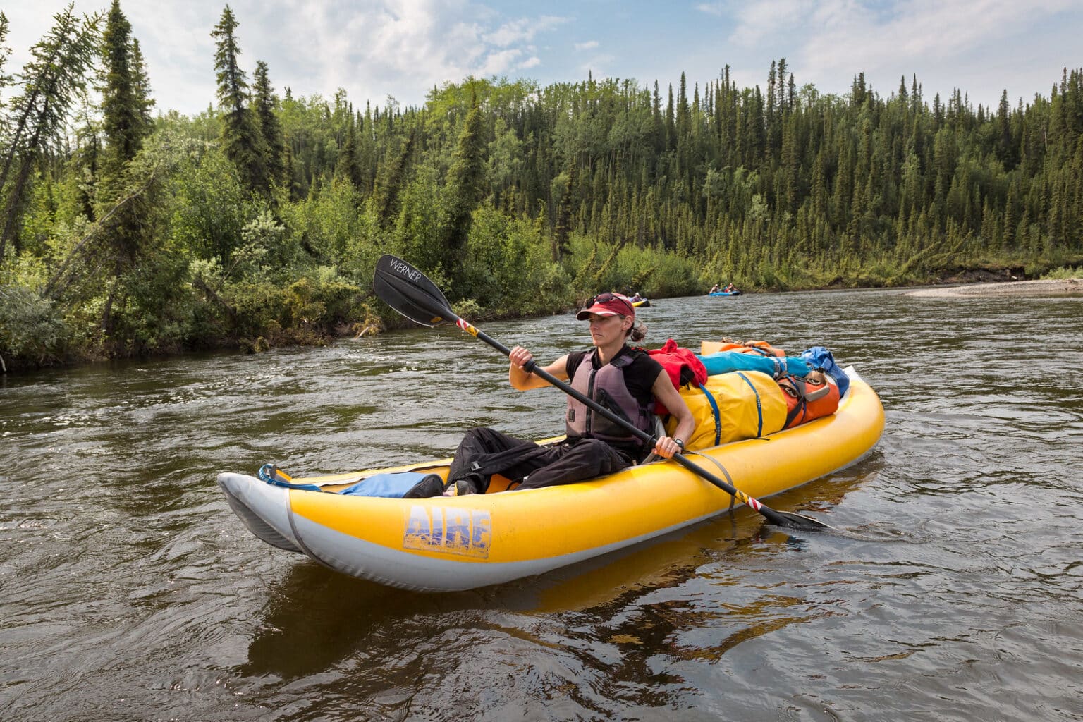 Yellow inflatable touring kayak floating on a flowing river